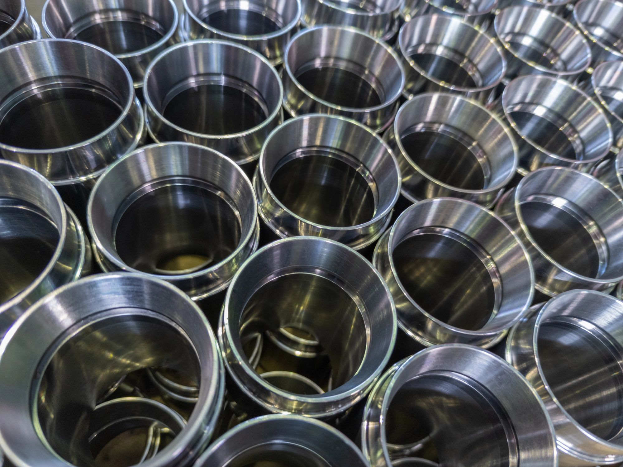 dark industrial background with cnc machined shiny steel pipes - selective focus and lens blur tech