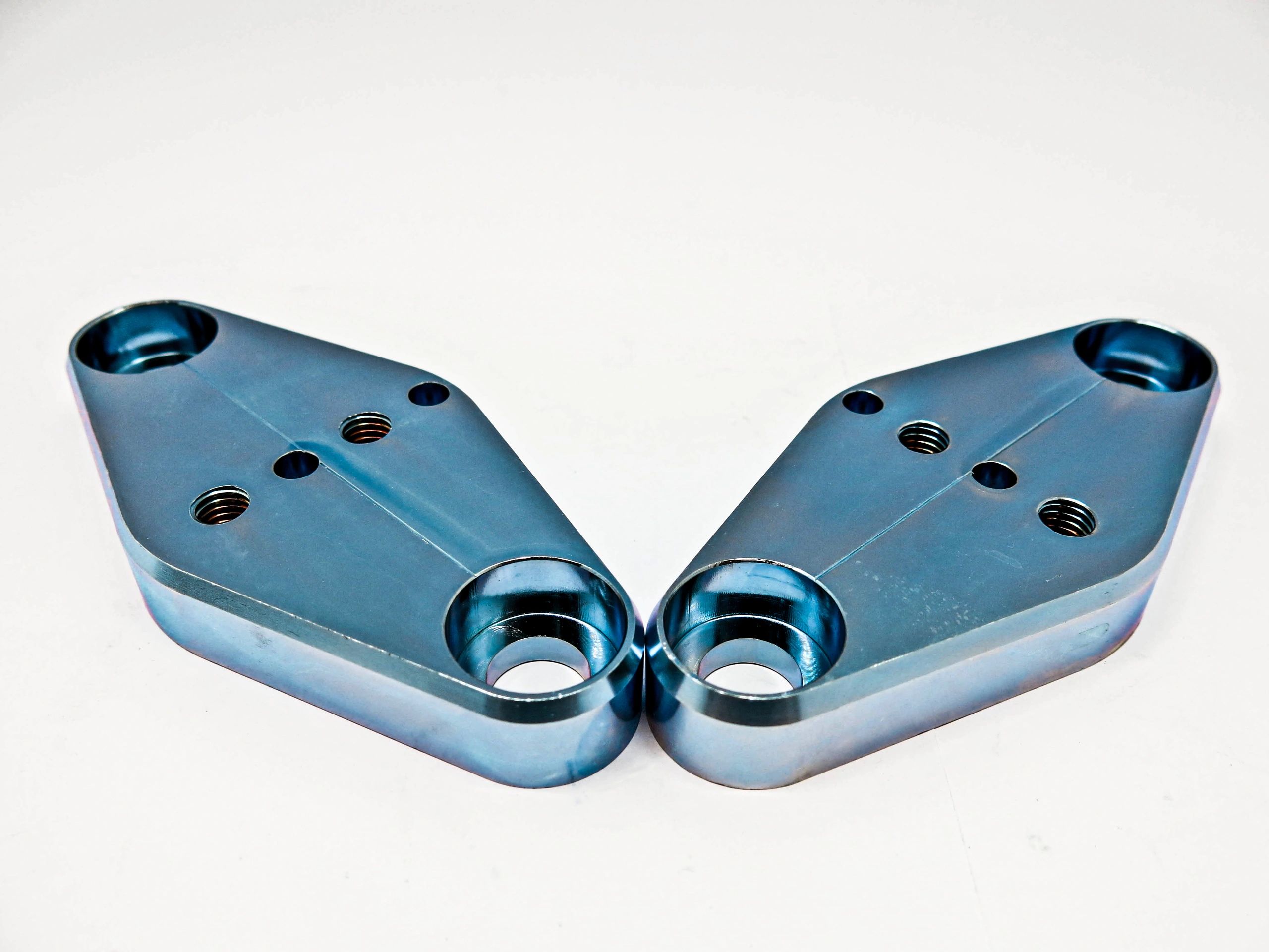 Iron metal, stainless steel, aluminum, chrome plated, silver bronze mixed with blue, 2 pieces perforated, screwed, facing each other, placed on a white background.